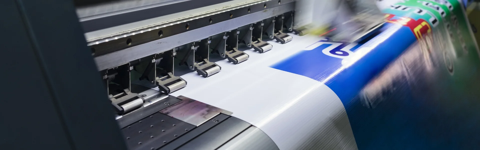 Impressora de grande formato produzindo uma lona colorida